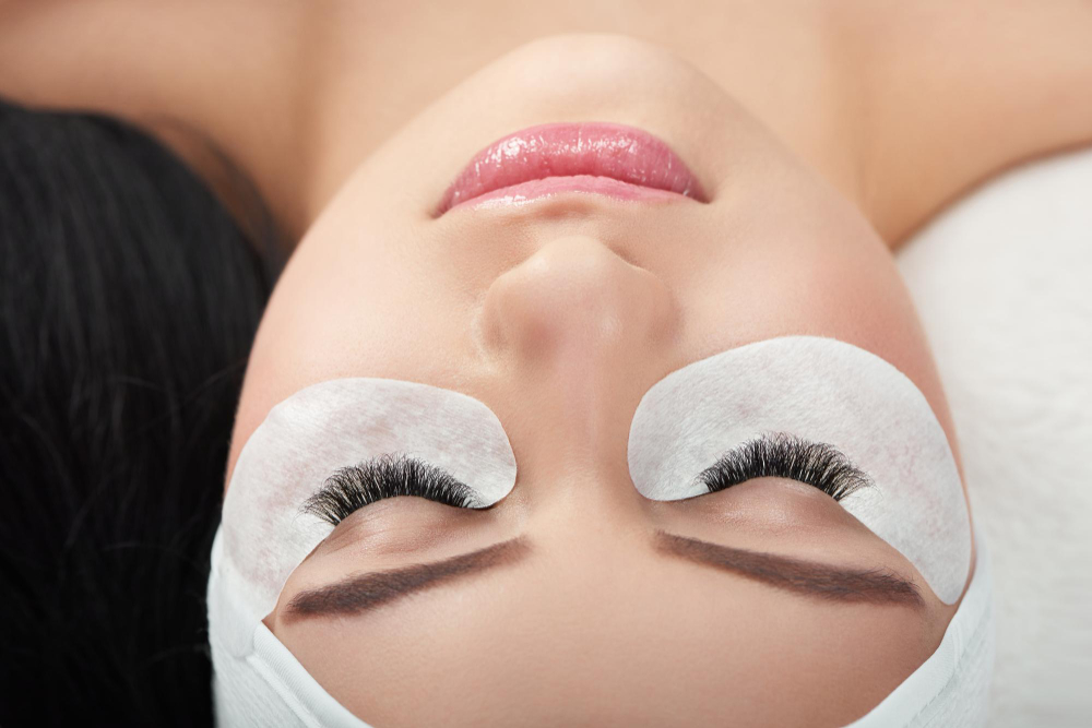 Profissional da Luxe Lash Design realizando procedimento de extensão de cílios com precisão